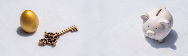 白色背景下有金蛋和钥匙的储蓄罐。横幅省钱是成功的关键图片下载
