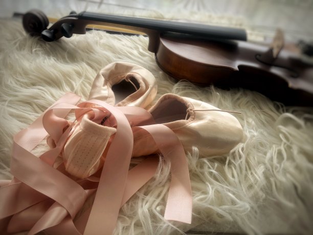 芭蕾舞鞋和小提琴穿上丝绒布，四周灯光朦胧图片下载