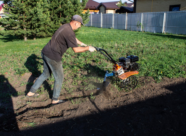 一个人在田里工作——穿着工作服的犁头在滴落着马达图片下载
