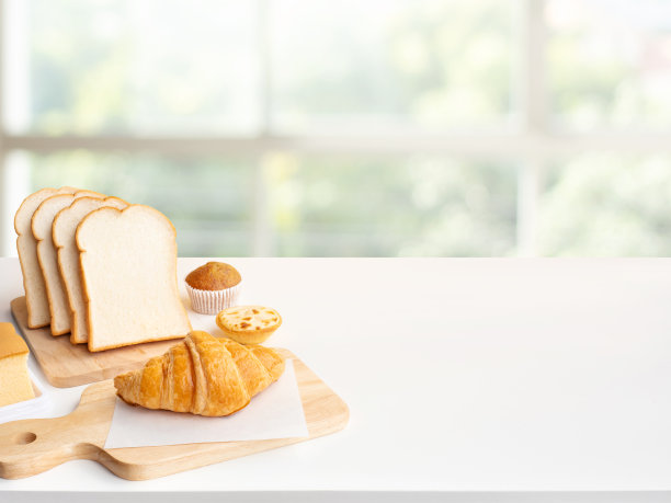 一套早餐食品或面包房，蛋糕在餐桌厨房与窗户背景图片下载
