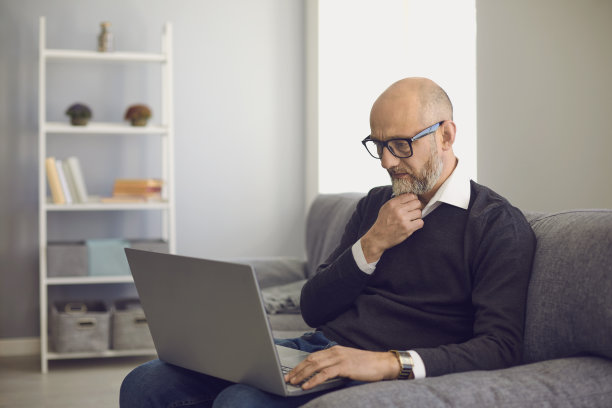 用笔记本电脑进行在线交流、工作、咨询医生或在家学习教育课程的老年人图片下载