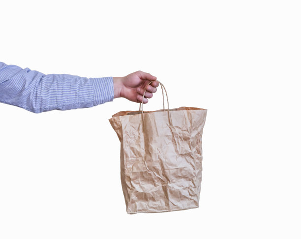 男子手持牛皮纸环保袋，白色背景图片下载