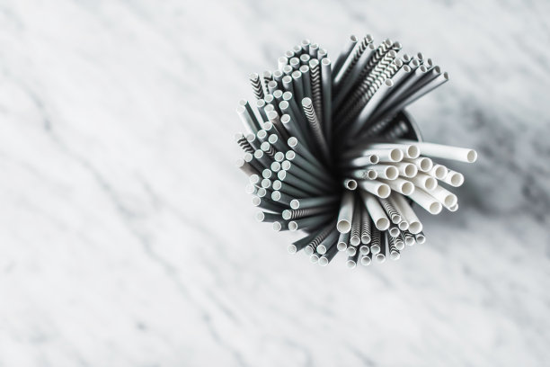 一组不同的纸饮用吸管在灰色的混凝土背景咖啡馆特写。可回收、不含塑料、环保。停止环境污染。图片下载