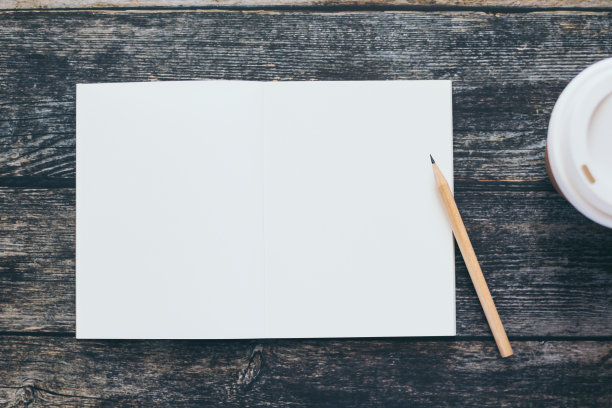 白色空白笔记本或普通记事本或日记本或日记本，用于书写文字和信息，铅笔和咖啡杯放在旧木桌或书桌上作为背景，有拷贝空间。仍然生活方式照片的概念。图片下载