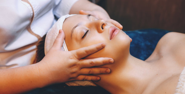 侧视图照片的可爱的白人妇女有一个放松的面部按摩在水疗沙龙图片下载