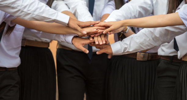 一群男人穿着白衬衫站在户外握手，概念团队合作。图片下载