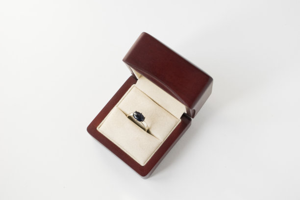 镶有蓝色蓝宝石的白色金戒指。孤立在灰色背景。图片下载