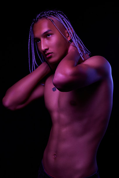 一个年轻的非洲人在工作室的肖像。高级时装男模特在五颜六色的霓虹灯下在黑色背景下摆姿势。艺术设计的概念。有选择性的重点图片下载