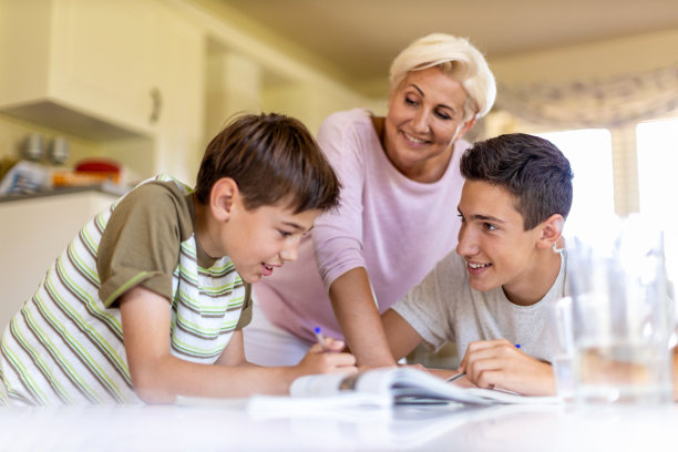 妈妈在家里帮助她的孩子做家庭作业图片下载