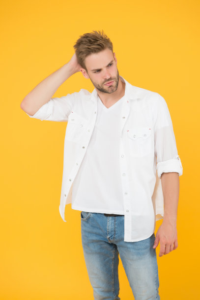 穿着牛仔裤和衬衫的商人。穿着休闲装的千禧男人的肖像。帅气的男人穿着白色t恤在工作室摆姿势。随意地英俊。城市休闲生活方式图片下载