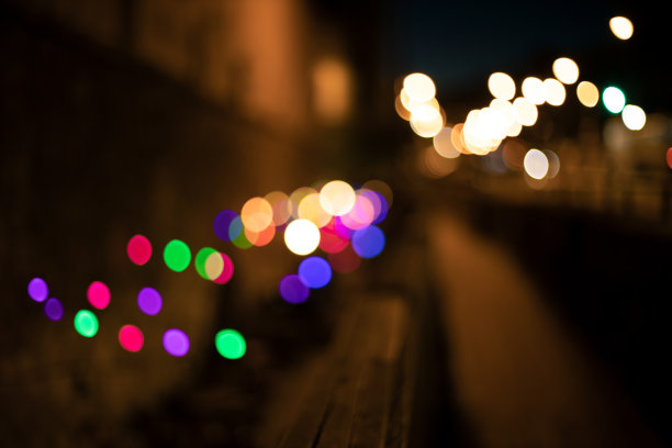 夜晚的城市街道抽象出焦点照明照明彩色的花环灯红、绿、黄、蓝的颜色和黑暗的气氛的散步边图片下载