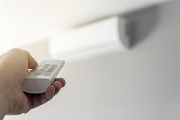 一个男人用遥控器关掉空调图片下载