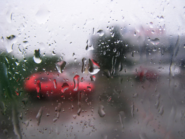 水滴落在俯瞰街道的玻璃上。车窗和后面的路。城市主题图片库设计图片下载