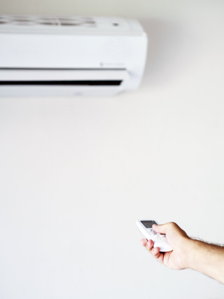 年轻人用遥控器打开空调图片下载