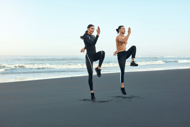 健康。在海滩上跑步。运动夫妇在时尚运动服装在海岸工作。男和女户外训练。在热带海上度过一个活跃的暑假。图片下载