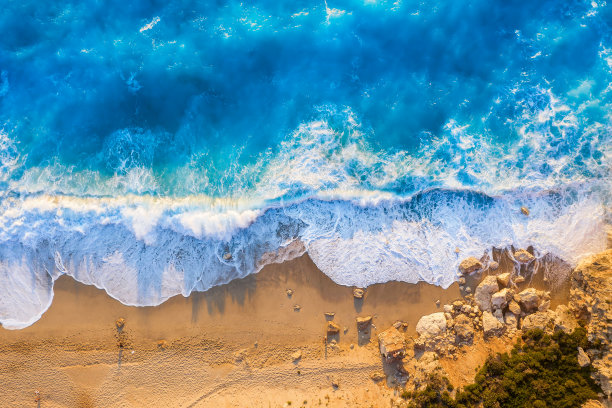 希腊莱夫卡达岛上的米洛斯海滩的金色海滩和荧光蓝色海的顶视图图片下载