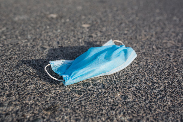 丢弃在大街上的一次性医用口罩。污染的概念。图片下载