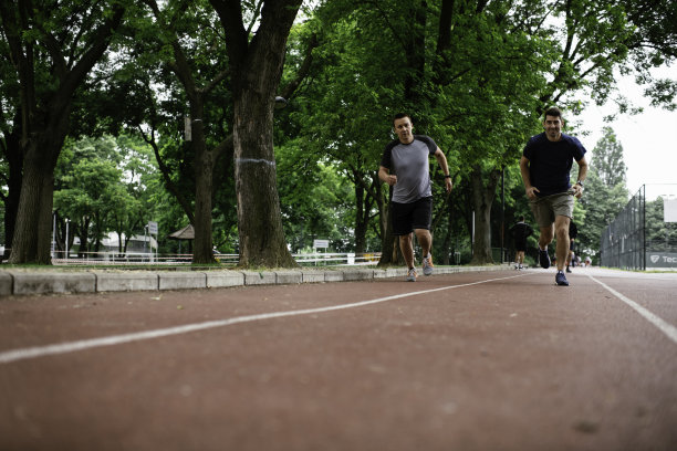 两个年轻的朋友在田径场上跑步图片下载