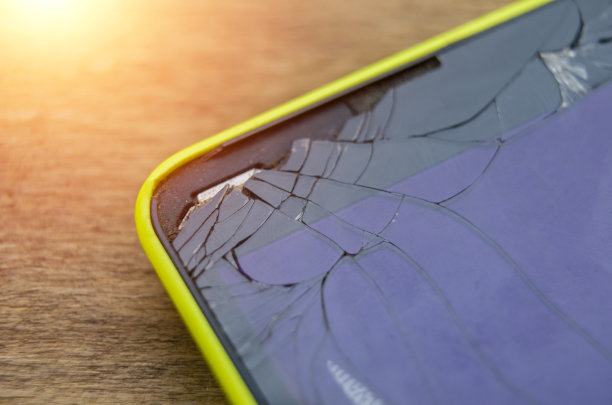 微距照片的黄色手机与一个破碎的显示器耀斑图片下载