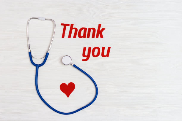 听诊器蓝色，红色的心和文字“谢谢你”在白色木制背景和复制空间。医疗保健和医疗理念。世界卫生日。从以上观点。图片下载