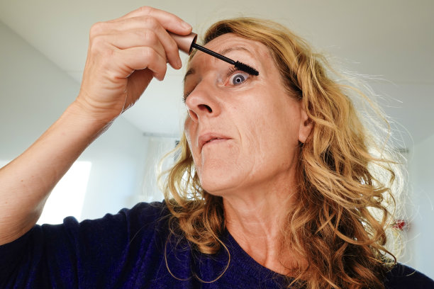 中年妇女涂睫毛膏。图片下载