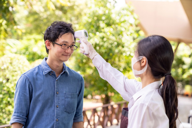 新常态服务员为顾客量体温图片下载