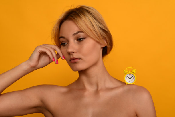 一个年轻美丽的女孩的肖像，时钟在肩上。衰老的概念。图片下载