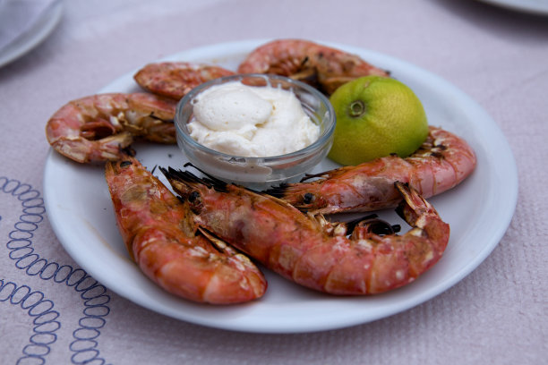 用白盘子盛着酱汁和酸橙的大虾图片下载