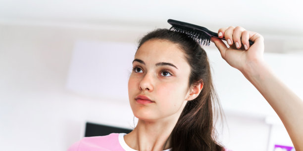 年轻女子用黑色的发刷梳成马尾辫图片下载