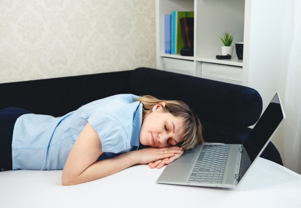 累了女性睡觉。昏昏欲睡的女孩坐在笔记本电脑前远程工作图片下载