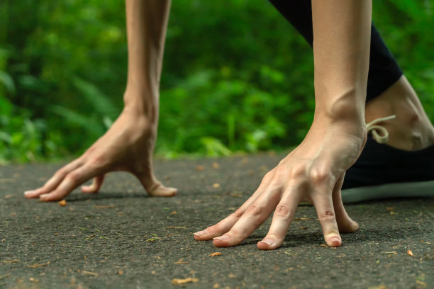女人在低起点前奔跑，照片上没有脸。女人的手放在低处开始靠近图片下载