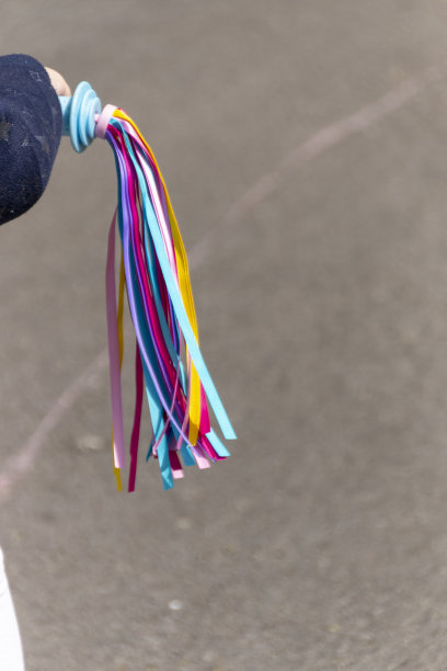 一个小女孩自行车上鲜艳的流苏的近景图片下载