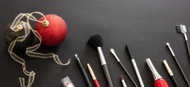 化妆刷和圣诞装饰对黑色背景，复制空间图片下载