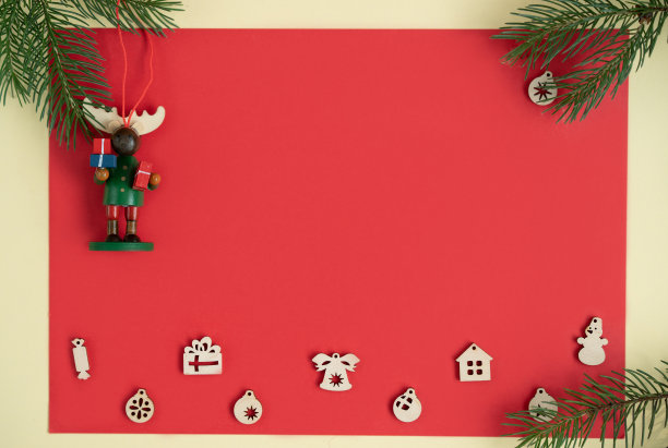 在红色背景的冷杉树枝和木制圣诞玩具，圣诞鹿和礼物。圣诞贺卡，diy概念。平铺，模拟，复制空间。新年。图片下载