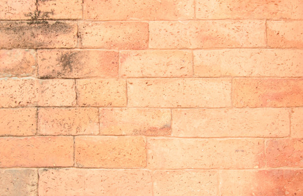 背景是宽大的老红砖墙纹理。旧橙色砖墙混凝土或石墙有纹理，墙纸石灰石抽象地板/网格不平的室内岩石。家庭或办公室设计背景。图片下载