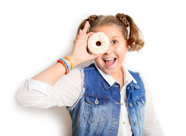 女学生在白色背景上吃甜甜圈图片下载