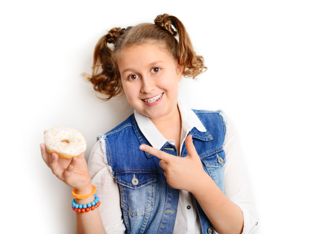 女学生在白色背景上吃甜甜圈图片下载