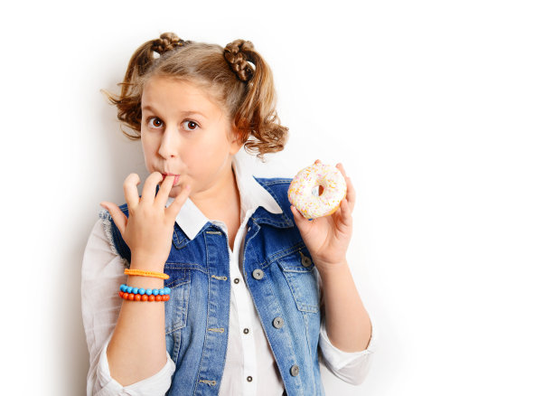 女学生在白色背景上吃甜甜圈图片下载