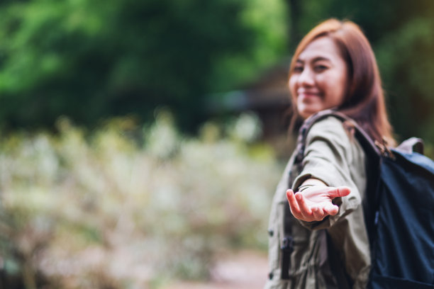 一个年轻的女旅行者手牵着手，引进山涧图片下载