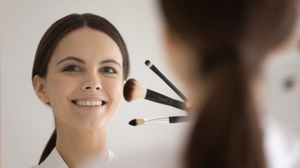 大头镜反射美丽的女人拿着化妆刷图片下载