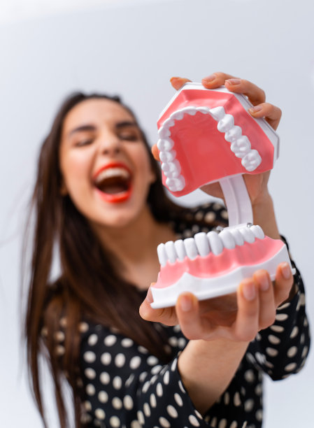 闭着眼睛，张着嘴的女人。小女孩抱着开了牙的牙床近脸。牙科的概念。有趣的情绪。图片下载