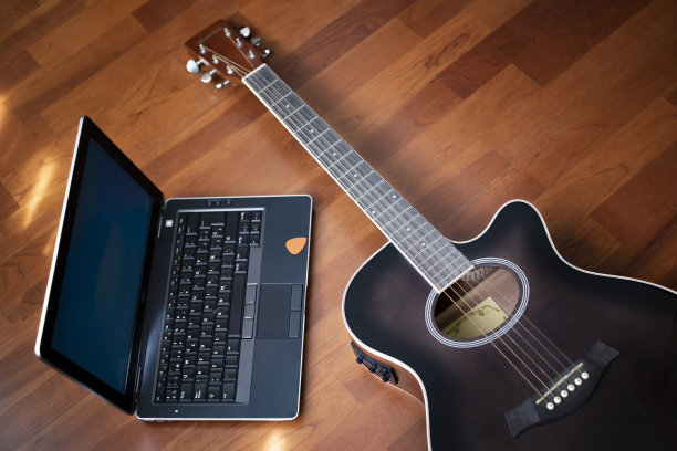 原声吉他旁边的笔记本电脑与挑选在线吉他课程图片下载