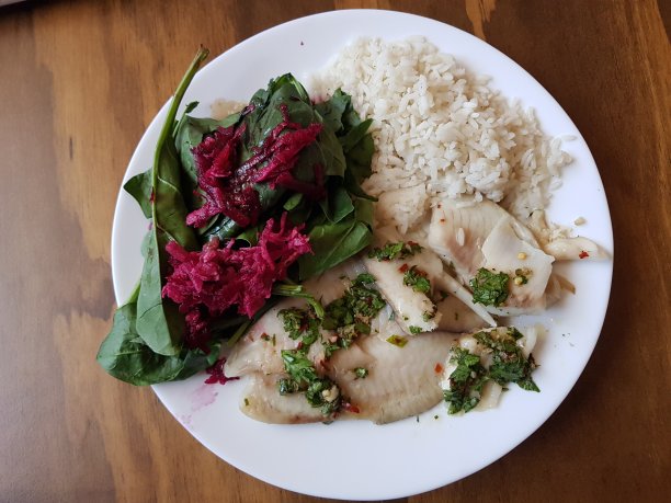 以木为背景，以鱼、沙拉、甜菜和米饭为佐料的一道菜图片下载