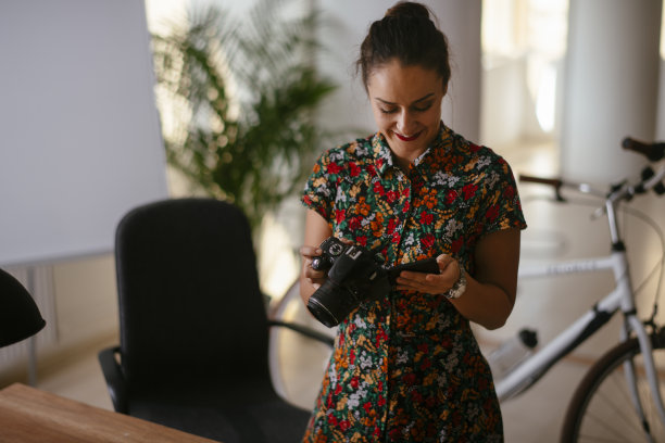 年轻的女商人在办公室里打电话。图片下载
