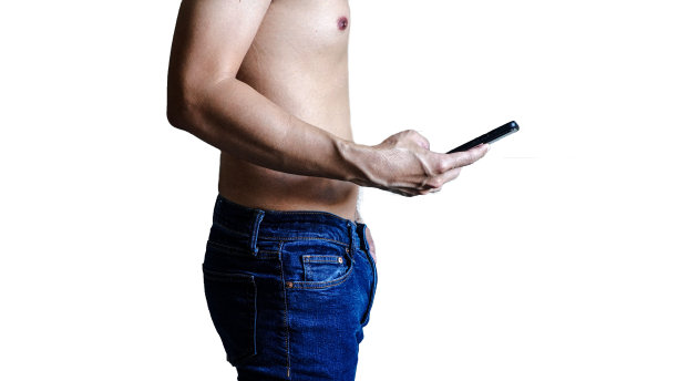 手机上播放的男士牛仔裤，节食减肥理念，白色背景图片下载