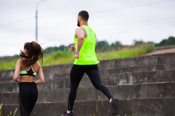 运动男孩和女孩在时尚的运动服在楼梯上跑步，照片为博客和体育和健康的生活方式的广告图片下载