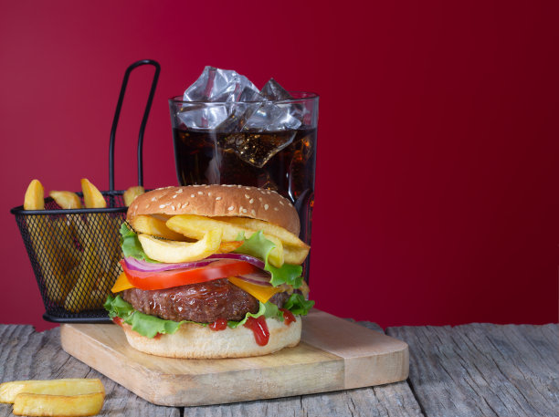 新鲜多汁的牛肉汉堡与炸薯条和可乐放置在木背景上图片下载