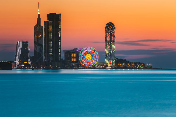 巴统,Adjara,格鲁吉亚。日落日出时度假小镇的天际线。明亮的橙色夜空。从海上看，以现代城市建筑、摩天大楼和塔楼照亮城市景观。金色的小时图片下载