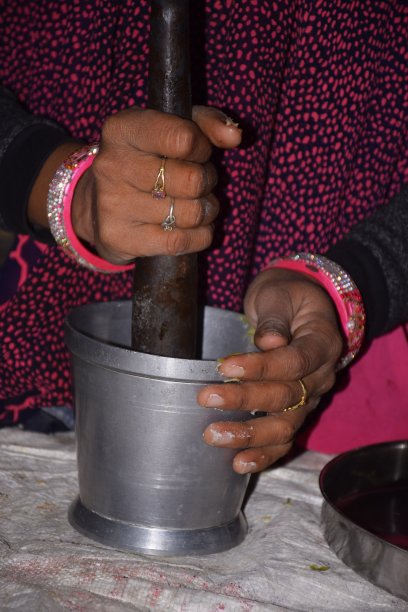 一名印度农村妇女正在磨香料制作蔬菜。图片下载