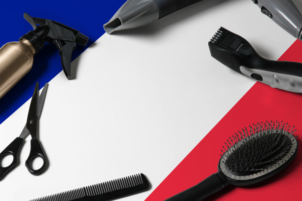 法国国旗和理发工具。梳子，剪刀和美发工具在一个美容院的桌面在一个国家木制背景。图片下载
